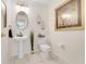 Stylish half bath with a pedestal sink, modern lighting, and decorative accents at 2256 Wekiva Village Ln, Apopka, FL 32703