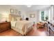 Cozy primary bedroom with hardwood floors, a large bed, and natural light at 2256 Wekiva Village Ln, Apopka, FL 32703