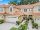 Charming townhome featuring a tile roof, a two-car garage, and a landscaped walkway leading to the front door at 2256 Wekiva Village Ln, Apopka, FL 32703