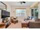 Comfortable living room with leather seating, neutral carpet, and a large window at 2256 Wekiva Village Ln, Apopka, FL 32703