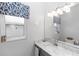 Cozy half-bathroom features a marble vanity, neutral wall color and window at 2423 Turnberry Dr, Oviedo, FL 32765