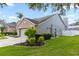 Well-maintained home showcasing a side entry garage, landscaped yard, and exterior paint at 2423 Turnberry Dr, Oviedo, FL 32765