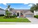 Charming single-story home featuring manicured landscaping, a brick facade, and a welcoming front porch with seating at 2423 Turnberry Dr, Oviedo, FL 32765