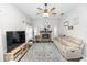 Cozy living room with a stone fireplace, ceiling fan, and neutral-toned furnishings at 2423 Turnberry Dr, Oviedo, FL 32765