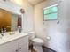 Modest bathroom featuring updated vanity and toilet, illuminated by a window at 3300 Glen Village Ct, Orlando, FL 32822