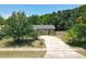 Single-story home on a cracked driveway framed by mature trees and greenery, with hints of blue sky above at 3300 Glen Village Ct, Orlando, FL 32822