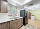Updated kitchen with stainless steel sink, modern faucet, and black refrigerator next to a light-filled dining area at 3300 Glen Village Ct, Orlando, FL 32822