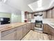 Well-equipped kitchen with grey cabinets, modern appliances, and a breakfast bar offering a view to the living area at 3300 Glen Village Ct, Orlando, FL 32822