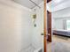 Enclosed shower featuring white tiles and a glimpse into an adjacent bedroom at 3300 Glen Village Ct, Orlando, FL 32822