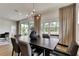 Dining area with a modern chandelier, large windows, neutral curtains, and access to the lanai at 5793 Timber Meadow Way, St Cloud, FL 34771