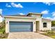 Attractive single-story house showcasing a blue garage door, manicured lawn and tasteful landscaping at 5793 Timber Meadow Way, St Cloud, FL 34771