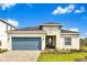 Charming single-story home featuring a blue garage door, landscaped front yard, and a welcoming entrance at 5793 Timber Meadow Way, St Cloud, FL 34771