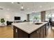 Open-concept kitchen featuring a large island with a sink, pendant lighting, and seamless flow to the living area at 5793 Timber Meadow Way, St Cloud, FL 34771