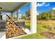 Covered patio with wood pile, outdoor seating and views of the green lawn and community landscaping at 5793 Timber Meadow Way, St Cloud, FL 34771