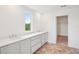 Bright bathroom features a double sink vanity with a large window, and doorway to walk-in closet at 2199 Broadbrook Drive, St Cloud, FL 34771