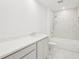 Bright bathroom featuring white marble style tile, a shower and tub combo, and a white sink and vanity at 2199 Broadbrook Drive, St Cloud, FL 34771