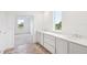 Bright bathroom features a double sink vanity with a large window, and doorway to the bedroom at 2199 Broadbrook Drive, St Cloud, FL 34771
