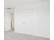 Minimalist bedroom featuring plush carpeting, clean white walls, white base trim, and a white closet door at 2199 Broadbrook Drive, St Cloud, FL 34771