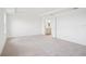 Bright and airy bedroom features neutral carpeting and doorway to the ensuite bathroom with white cabinets at 2199 Broadbrook Drive, St Cloud, FL 34771