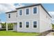 The home's exterior includes gray siding, white trim, a covered patio, and a lush, green lawn at 2199 Broadbrook Drive, St Cloud, FL 34771