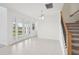Bright living room features neutral tile flooring, staircase, chandelier, and outdoor access at 2199 Broadbrook Drive, St Cloud, FL 34771