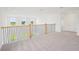 Upstairs loft with neutral carpet and railing showcasing an open-concept design at 2199 Broadbrook Drive, St Cloud, FL 34771