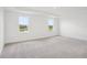 Main bedroom with neutral carpet and two windows overlooking scenic lake views at 2199 Broadbrook Drive, St Cloud, FL 34771
