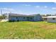 This home features a spacious backyard with a blue house, grassy lawn, and storage shed at 2902 Wheeler St, Bartow, FL 33830
