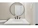 Bathroom featuring a white vanity with black hardware, a round mirror, and a tiled shower and toilet at 2902 Wheeler St, Bartow, FL 33830