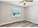 A bright bedroom features gray wood floors, a ceiling fan, and a window with natural light at 2902 Wheeler St, Bartow, FL 33830