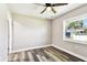 A bright bedroom boasts gray wood floors, a ceiling fan, and a window to let in natural light at 2902 Wheeler St, Bartow, FL 33830
