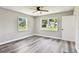 Bedroom featuring wood-look flooring, a ceiling fan, and two windows overlooking the yard at 2902 Wheeler St, Bartow, FL 33830