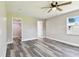 Spacious bedroom with wood-look flooring, a ceiling fan, and a view through the window at 2902 Wheeler St, Bartow, FL 33830