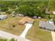 An aerial view of a single story home with a driveway and well manicured lawn at 21078 Sw Honeysuckle St, Dunnellon, FL 34431