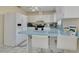 Bright kitchen with white cabinetry, blue countertops, breakfast bar, and modern appliances at 21078 Sw Honeysuckle St, Dunnellon, FL 34431