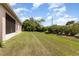 A huge backyard with a manicured lawn, established shrubbery and views of the home at 3235 Grand Pines Dr, Lakeland, FL 33810