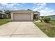 Long concrete driveway leading up to a two car garage attached to this single story home at 3235 Grand Pines Dr, Lakeland, FL 33810