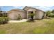 Charming one-story home featuring a lush front yard, covered entryway, and attached garage at 3235 Grand Pines Dr, Lakeland, FL 33810