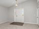 Bright foyer featuring carpeted floors, a stylish light fixture, and a white door on the right at 3235 Grand Pines Dr, Lakeland, FL 33810