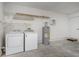 A clean laundry room with a washer, dryer, water heater and convenient overhead shelving at 3235 Grand Pines Dr, Lakeland, FL 33810