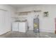 A clean laundry room with a washer, dryer, water heater and convenient overhead shelving at 3235 Grand Pines Dr, Lakeland, FL 33810