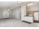 Open-concept living room and kitchen with neutral tones, plush carpet, and a cozy breakfast bar at 3235 Grand Pines Dr, Lakeland, FL 33810
