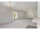Open living room with carpeted floors, a chandelier, and a large window letting in natural light at 3235 Grand Pines Dr, Lakeland, FL 33810