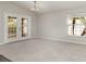 Spacious living room featuring carpeted floors, French doors, and a large window that offers a green view at 3235 Grand Pines Dr, Lakeland, FL 33810