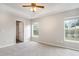 Main bedroom featuring plush carpet, a ceiling fan, and large windows for natural light at 3235 Grand Pines Dr, Lakeland, FL 33810