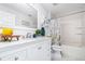 Bright bathroom features a white marble countertop, white cabinets and white-tiled shower and flooring at 3321 Pintello Ave, New Smyrna Beach, FL 32168