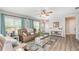 Bright living room with neutral walls, wood-look floors, and lots of natural light from large windows at 3321 Pintello Ave, New Smyrna Beach, FL 32168