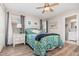 Cozy main bedroom with a ceiling fan, wood-look floors, and an ensuite bathroom at 3321 Pintello Ave, New Smyrna Beach, FL 32168