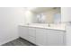 Bathroom with double vanity, white cabinets and countertops, and a large mirror at 781 Poppy Ln, Dundee, FL 33838