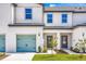Townhome exterior with modern doors, light green garage door, manicured lawn, and a tidy walkway to the front door at 781 Poppy Ln, Dundee, FL 33838